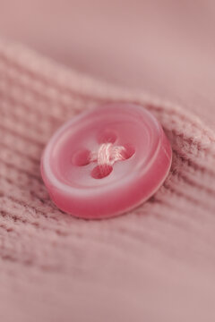 Bright pink button on soft fabric in close up view