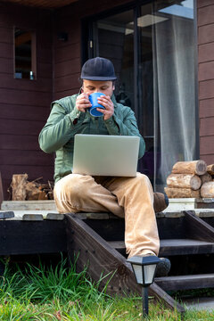 Freelance worker enjoying a warm beverage during outdoor office hours, vertical view