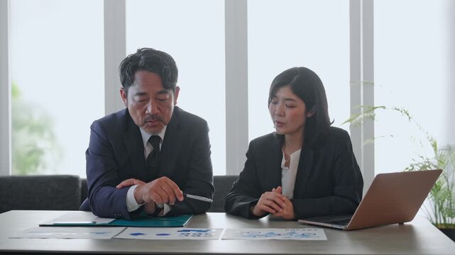 書類を見ながら会議する男女ビジネスパーソン。相談、商談、経営、チームワーク、マーケティング、指導