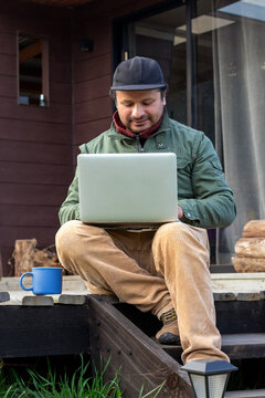 Remote worker or freelancer writing on his laptop with a coffee mug nearby