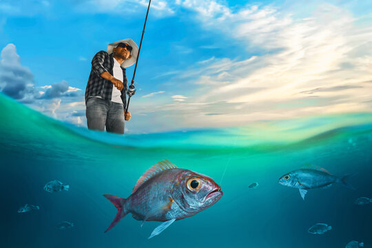 Man holding fishing rod and catching fish underwater