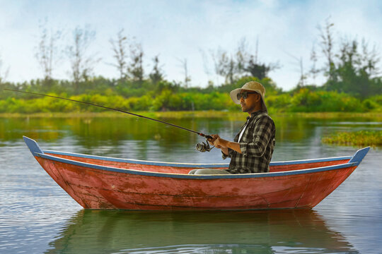 Man fishing from wooden boat on calm lake under blue sky