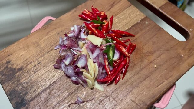 Chopped shallots garlic and red chili on wooden cutting board