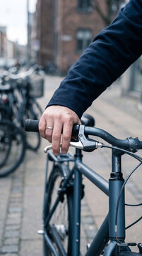 Hand on bicycle handlebar in city street