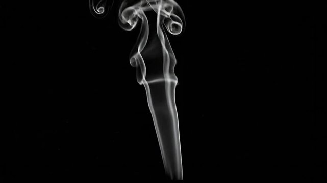 A delicate plume of white smoke rises against a deep black background