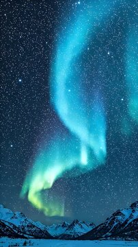 Aqua Blue Aurora Borealis Over Snowy Mountains - Stunning aurora borealis flows across a starry night sky above snow-covered mountains.