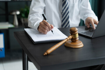 Fototapeta premium Lawyer checking documents and typing on laptop