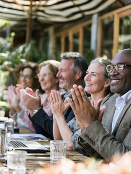 Group applauds warmly at outdoor table