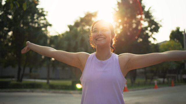 Asia young Gen Z people mindful happy woman open arm relax body deep stress relief outdoor nature green public park sun light self love anti aging life asian female mental health care modern medical.