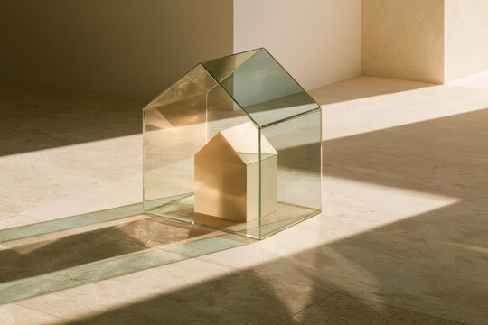 Glass house casts shadows on warm concrete floor