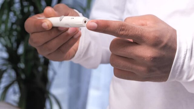 Close up of person demonstrating use of blood glucose meter for diabetes test