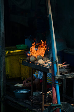 Traditional fish grilling over coconut embers in Sumatra