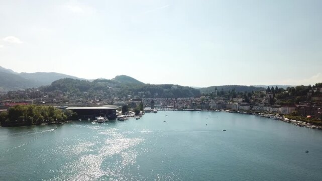 Drone glides lower toward central Lucerne, approaching the waterfront, KKL building and river outlet from above