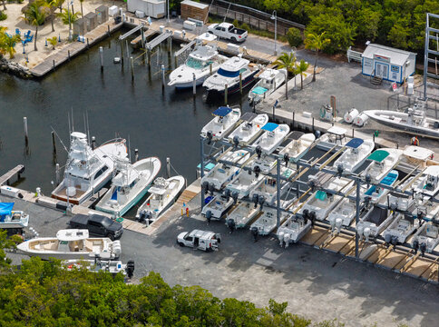 Aerial view of a marina in Islamorada with motorboats docked in the water and stored in a rack system