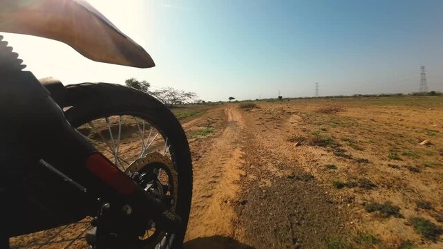 an offroad motorcycle traversing on a trail through semi arid landscapes of madhya pradesh