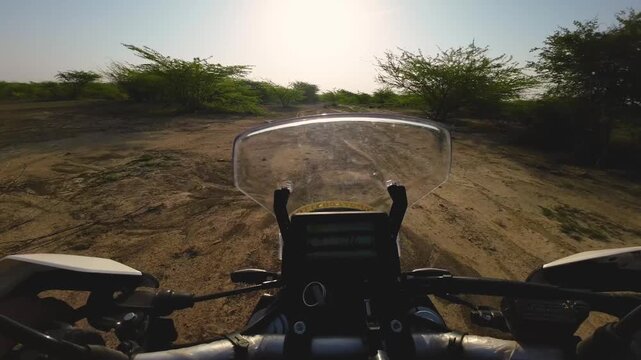 pov of riding motorbike on a trail through arid landscapes of madhya pradesh