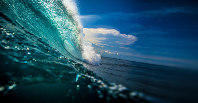 Perfect Ocean Wave Barrel Curling Under Blue Sky - Water Surface View