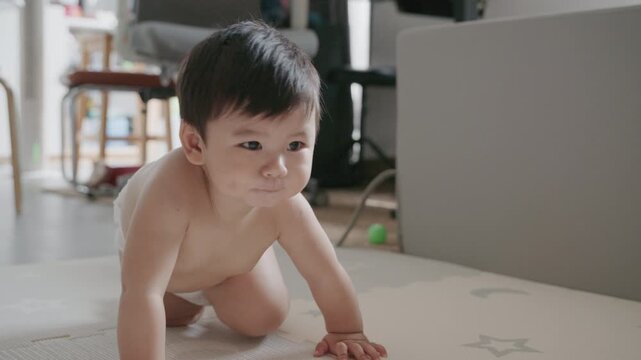 4K Cute Asian baby boy crawling on the floor and smiling happily.