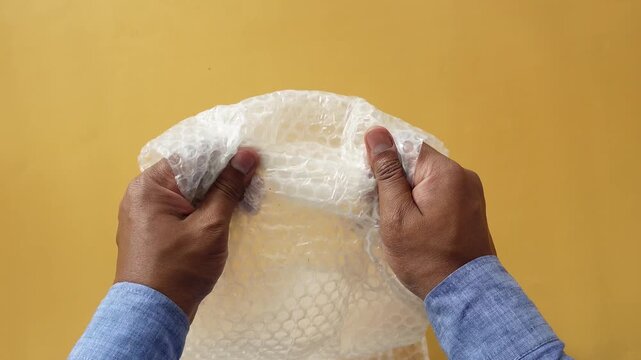 Close up of hands holding and crumpling bubble wrap package material