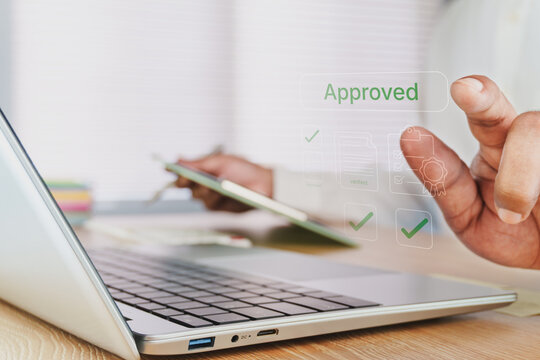 Business professional approving digital document on laptop, virtual approved confirmation interface, online workflow authorization, paperless office, compliance verification, secure business process