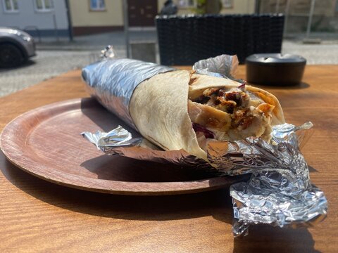 Frisch zubereiteter D&uuml;r&uuml;m D&ouml;ner mit saftigem Fleisch und Salat auf einem Teller. Street Food, Kebab, Fast Food, t&uuml;rkische K&uuml;che, Mittagessen und orientalischer Genuss.