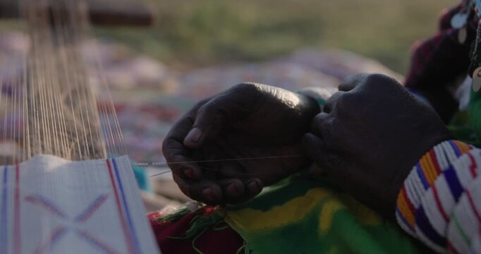Cinematic close up of traditional Kenyan weaving and handcrafted beadwork.