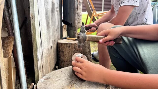 Side view of hands using traditional hammers on log stumps. Ideal for DIY tutorials, hardware store promotions, rustic craftsmanship ads, and manual labor concept videos.