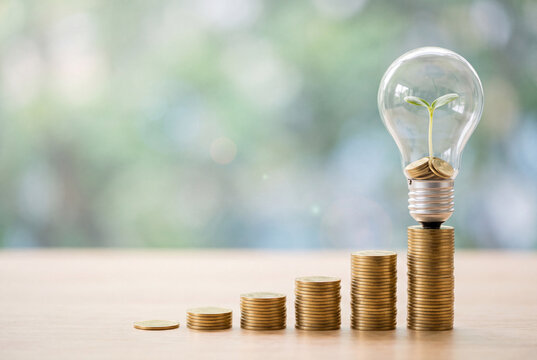Financial Growth Concept with Stacked Gold Coins and Light Bulb Sprout Symbolizing Sustainable Investment