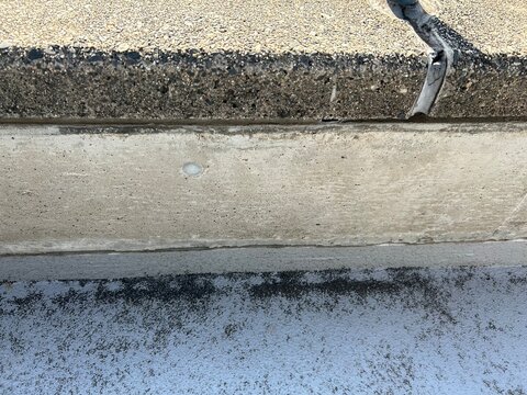 Weathered concrete curb texture with asphalt pavement
