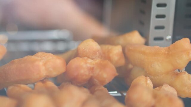 Close Up of Golden Fried Dough Sticks in a Glass Display Case