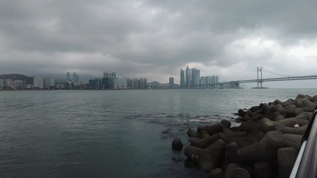 Panoramic View of Busan Cityscape and Gwangandaegyo Bridge under Cloudy Sky