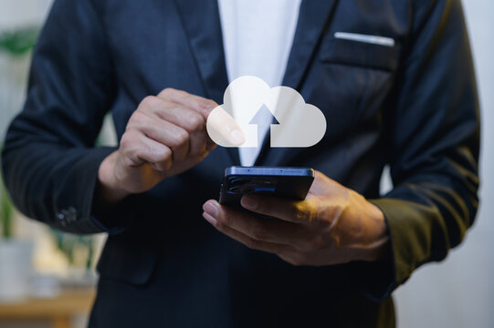 Businessman in Suit Holding Smartphone with Cloud Upload Icon in Office Setting