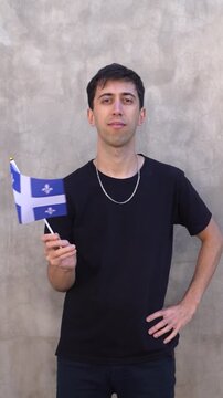 Adult person waving the Quebec flag. Vertical shot in slow motion.