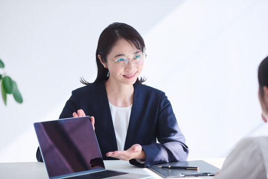 ノートパソコンを使い接客をする女性