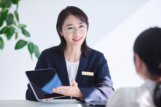 タブレット端末を使い接客をする女性