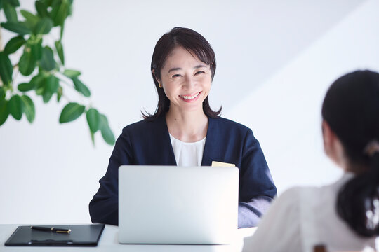 ノートパソコンを使い接客をする女性