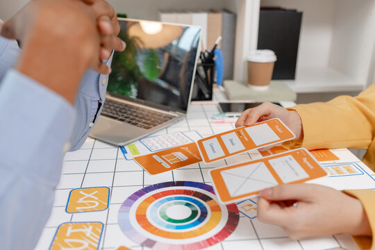 A UX designer presents wireframes, interface layouts, and mobile app concepts during a collaborative design workshop, improving user experience, product strategy, and digital interface planning.