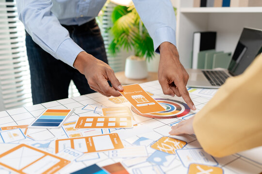 A UX design team collaborates with wireframes, interface cards, color palettes, and mobile app prototypes to improve user experience, design systems, product strategy, and digital innovation.