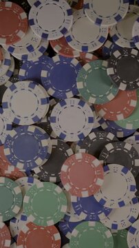 Untitled ProjectVertical 4K video panning across scattered red, blue, green, black and white poker chips creating a bright casino gaming background.