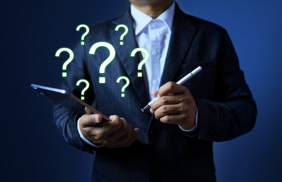 Business solution concept with businessman using tablet and question mark floating around represented find the opportunity and data analysis to solving the problem