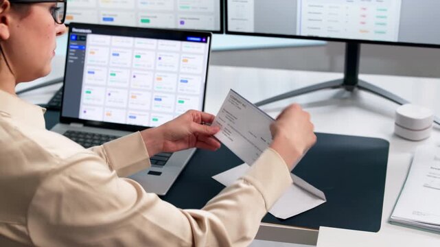 Woman Opening Emvelope With Payroll Check.