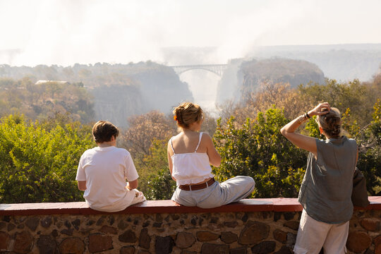 family looking at Victoria Falls and Bridge, Zimbabwe, Africa