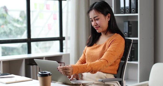 Asian woman working remotely from home, connecting with network, researching online, managing business, enjoying flexibility in modern digital lifestyle