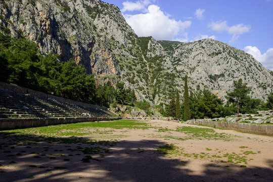 Tourists visit the ancient theater of Delphi, Greece, on a sunny day.