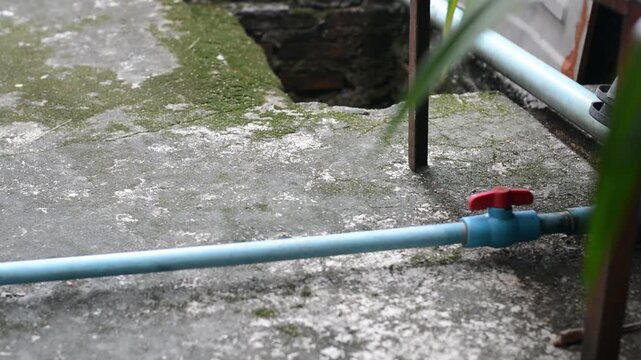 Water pipeline system with PVC pipe and plastic turn valve in backyard setup