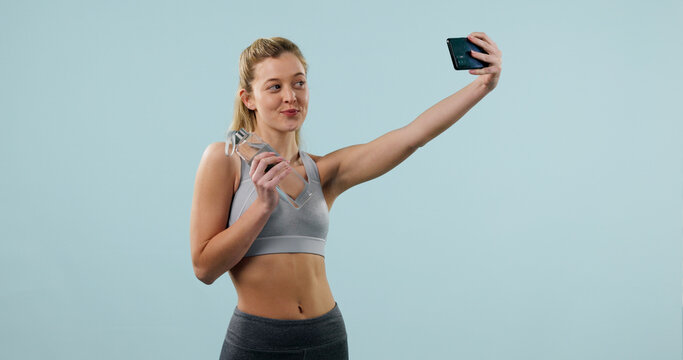 Woman, water bottle and selfie in studio for fitness, influencer and social media for gym space. Person, memory or post with content creation for exercise club, confidence and drink on background