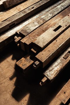 High angle view of stacked reclaimed timber beams with traditional joinery details.