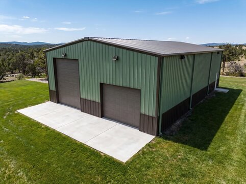 3D Illustration of Green Metal Pole Barn with Garage Doors on Concrete Pad