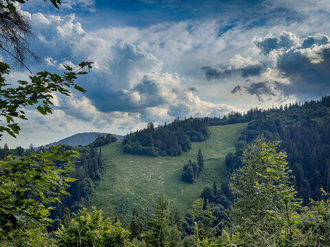 Sunny Carpathian peaks: green valleys and cloudy skies.