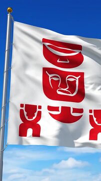 A white flag with red tribal symbols flies in the wind